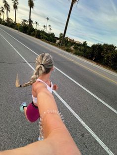 a woman is running down the street with her arm in the air while holding onto another person's hand