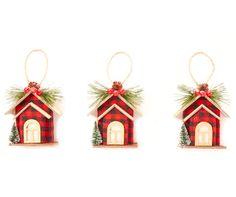 three christmas ornaments hanging from the side of a white wall, each with a red and green house on it