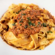 a white plate topped with pasta covered in sauce