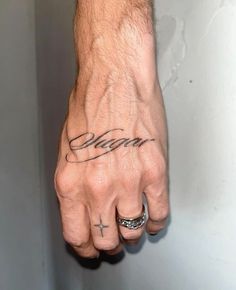 a man's hand with the word dream tattooed on it and a cross in the middle