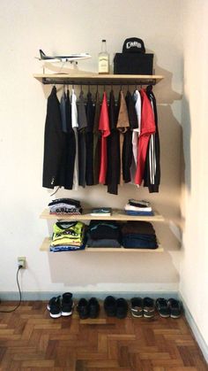 an organized closet with shoes, t - shirts and backpacks hanging on the wall