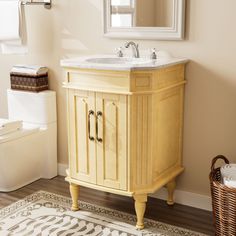 a bathroom with a sink, mirror and toilet in it's corner area next to a rug