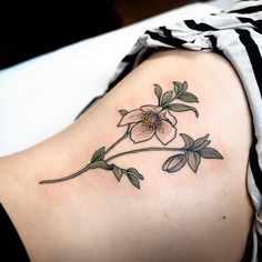 a woman's shoulder with a flower tattoo on her left side ribcage