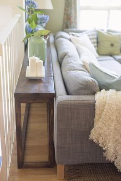 a living room with a couch, coffee table and vase on the end tables in front of it