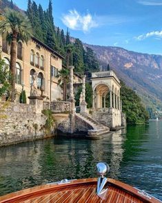 a boat traveling down a river next to a large building with columns on the side