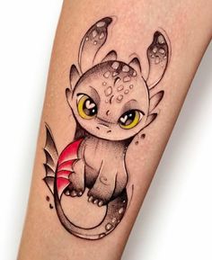 a tattoo with an image of a small dragon on it's leg and yellow eyes