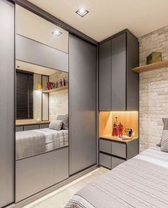 a bedroom with grey walls and white bedding, built - in shelving units