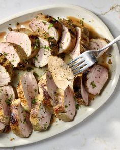 a white plate topped with sliced pork and potatoes