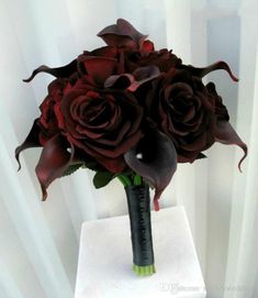 a bouquet of red roses sitting on top of a white table