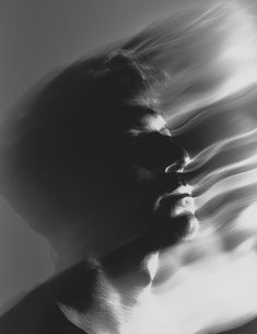 black and white photograph of a man's face with his hair blowing in the wind