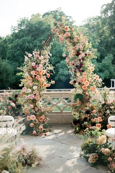 an outdoor wedding ceremony with flowers and greenery