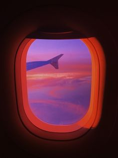 an airplane window looking out at the clouds