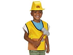 a young boy wearing a construction worker's outfit and holding a large hammer in his hand