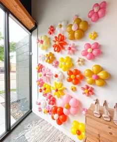 the wall is decorated with balloons and flowers