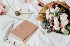 a bouquet of flowers sitting on top of a table next to a notebook and pen