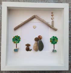 a white frame with rocks and stones in the shape of a house