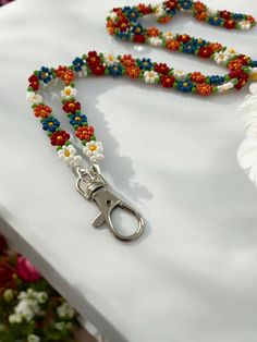 Embrace a playful, hippie vibe with this Colourful Beaded Daisy Chain Lanyard, a multicoloured flower design perfect as an interchangeable ID holder for nurses and teachers. This vibrant seed bead neck strap adds a fun and stylish touch to any name tag or badge. Included in your purchase are a pair of eyeglass chain ends and a lanyard clasp. To switch, simply use the small clasps at each end of the beaded chain.  This colourful flower lanyard is 30 inches long. To complete your ensemble, check o Beaded Lanyards Diy, Beaded Lanyards Badge Holders, Beaded Daisy Chain, Lanyard Beads, Beaded Sunglasses, Beaded Daisy, Eyeglass Strap, Seed Bead Flowers, Bead Flower