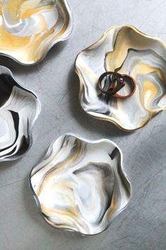 four bowls with rings in them sitting on a table