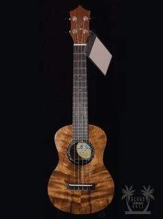 the ukulele is made out of wood and has a glass case on top