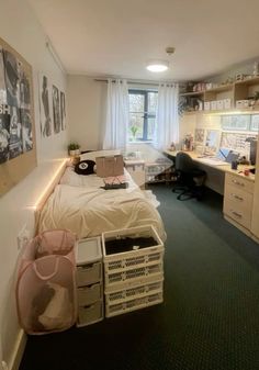 a room with a bed, desk and computer on the wall next to a window