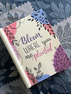 a book that is laying on top of a blanket with the words, bloom where you are planted