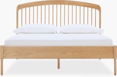 a wooden bed frame with two white pillows