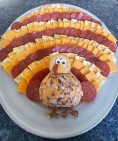 a turkey shaped platter with cheese, crackers and sausages on the side