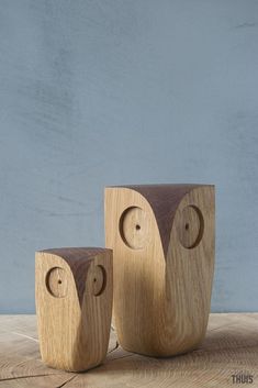 two wooden owls sitting next to each other