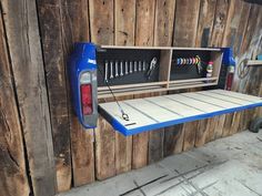 a blue shelf with tools hanging from it's sides