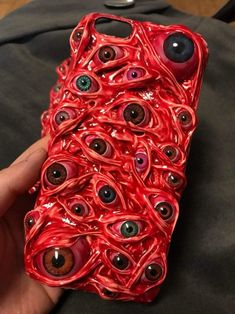 an iphone case made out of red plastic with eyeballs on it