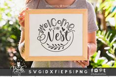 a woman holding up a framed sign with the words welcome to the west on it