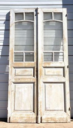 an old pair of double doors in front of a house