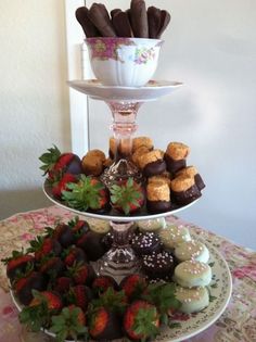 two tiered trays filled with chocolate covered strawberries and pastries next to each other