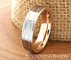 two gold wedding bands sitting next to each other on top of a burlock