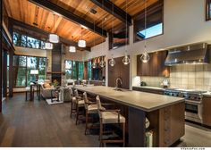 a large kitchen with an island in the middle and lots of windows on both sides