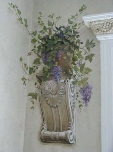 a vase filled with purple flowers sitting on top of a wall