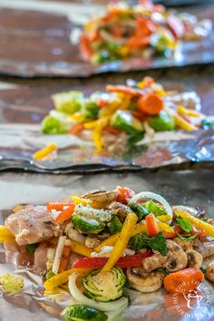 two plates filled with vegetables and meat on tinfoil covered baking sheet, ready to be eaten