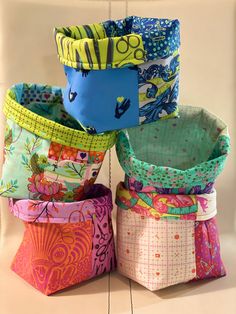 four colorful baskets are stacked on top of each other in the same pattern and color