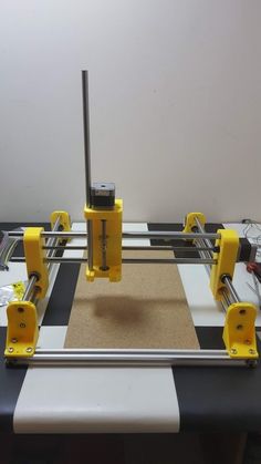 a machine that is sitting on top of some kind of table clothing mat with yellow and black handles