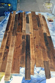 a wooden pallet sitting on top of a blue cloth covered floor next to a wall