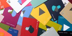 many different colored business cards with numbers and symbols on them, all stacked up together