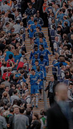 a crowd of people walking up and down stairs in the middle of a soccer field