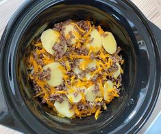 a crock pot filled with meat and cheese