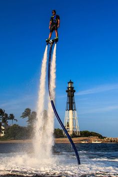 a man on a jet ski being pulled over the water by a large blue hose