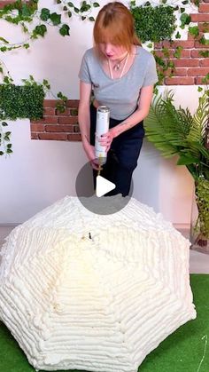 a woman standing on top of a white object with a can in it's hand