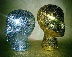 two gold and silver glittered head vases sitting side by side