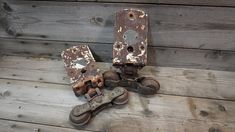 an old rusty door hinges on a wooden floor with other rusted parts