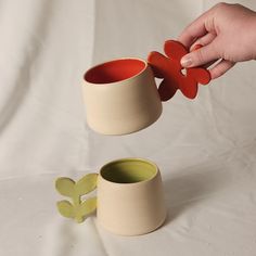 a person is holding a flower shaped cup