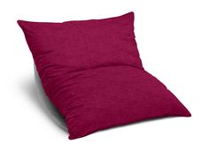 a red pillow sitting on top of a white chair