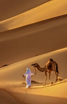 a man with a camel in the desert